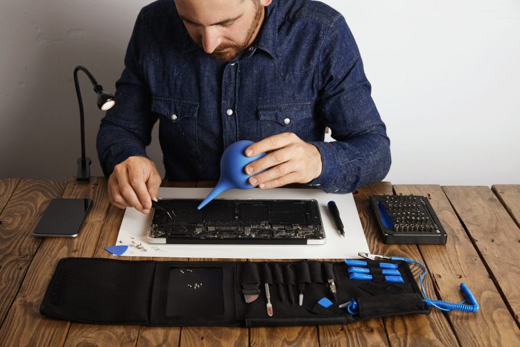 Professional is working in his lab to repair and clean computer laptop Toolkit box with specific instruments near